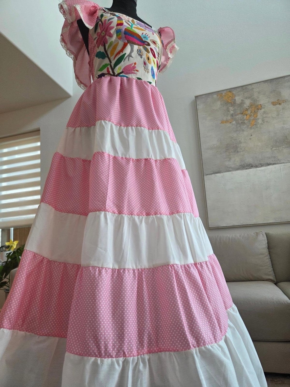 Maniquí con vestido rosa y blanco de rayas con top bordado a mano con motivos florales y mangas con vuelo